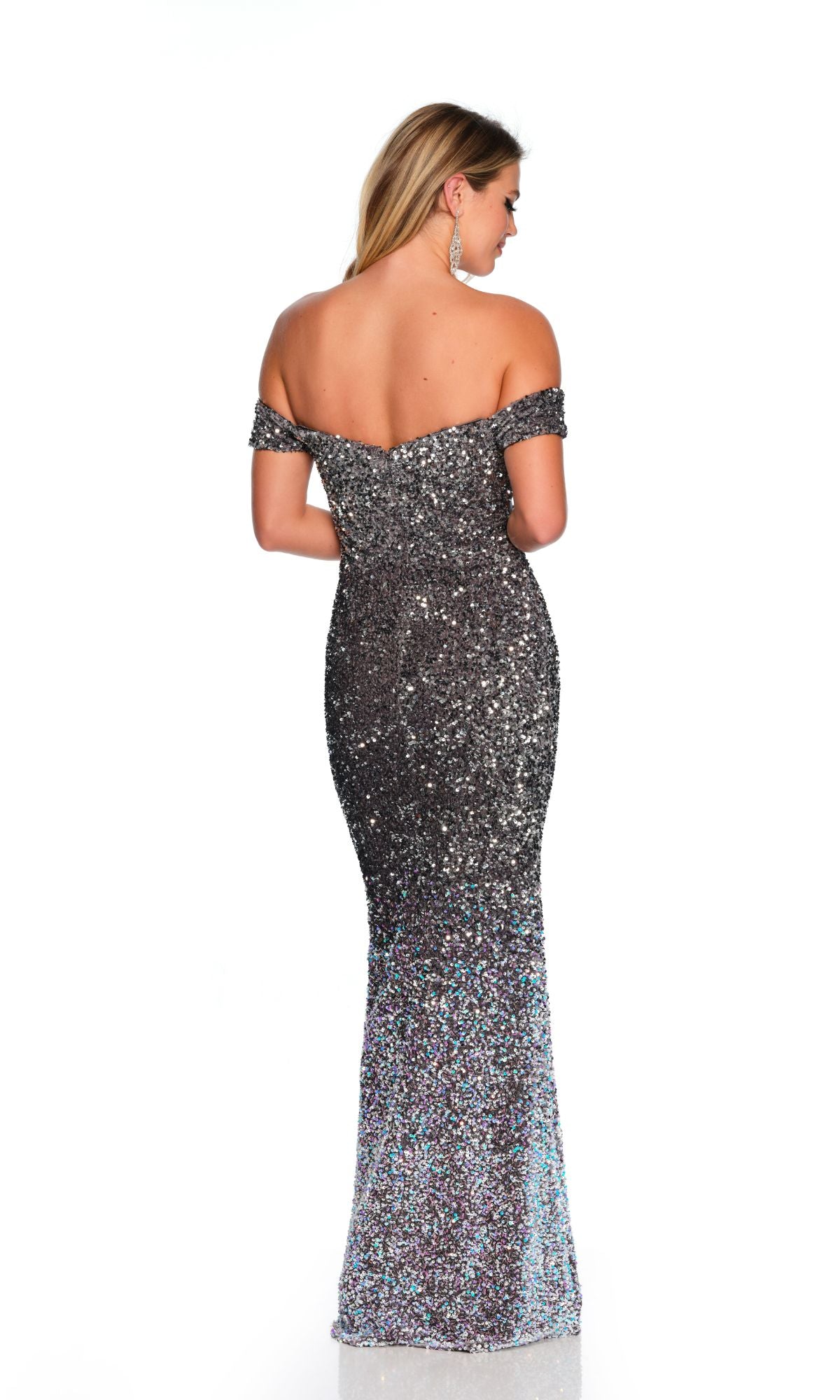 A woman stands with her back to the camera against a plain white background, wearing the Long Formal Dress 11489 by Dave and Johnny—an off-the-shoulder, floor-length sequin gown with a silver finish.